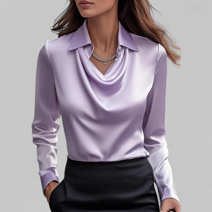 Woman wearing a light purple blouse with a plain background